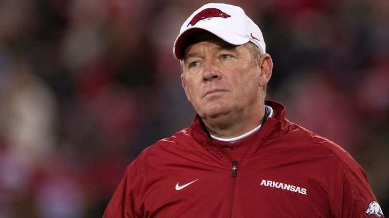 Bobby Petrino standing on the football field in Arkansas Razorbacks gear during a tense game moment.