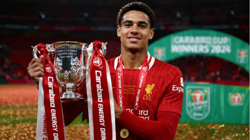 Jarell Quansah celebrates with the Carabao Cup trophy after a major Liverpool cup victory inside a confetti-filled stadium.