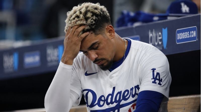 Miguel Vargas sitting in the Dodgers dugout looking frustrated during a difficult stretch with the team.
